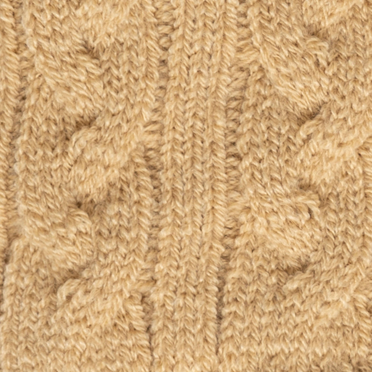 Women's cable knit gloves in beige, fabric close up.
