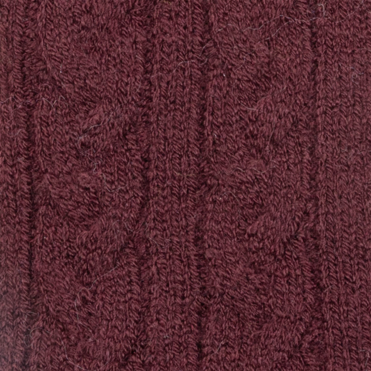 Women's cable knit gloves in burgundy, fabric close up.
