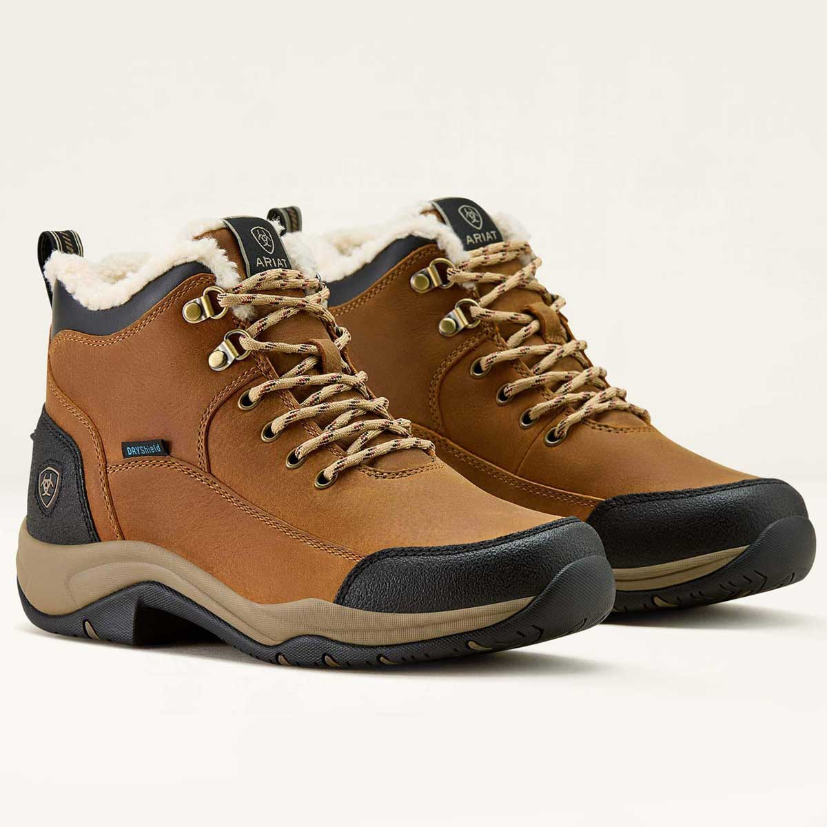 Pair of brown hiking boots with white lining on a light gray background