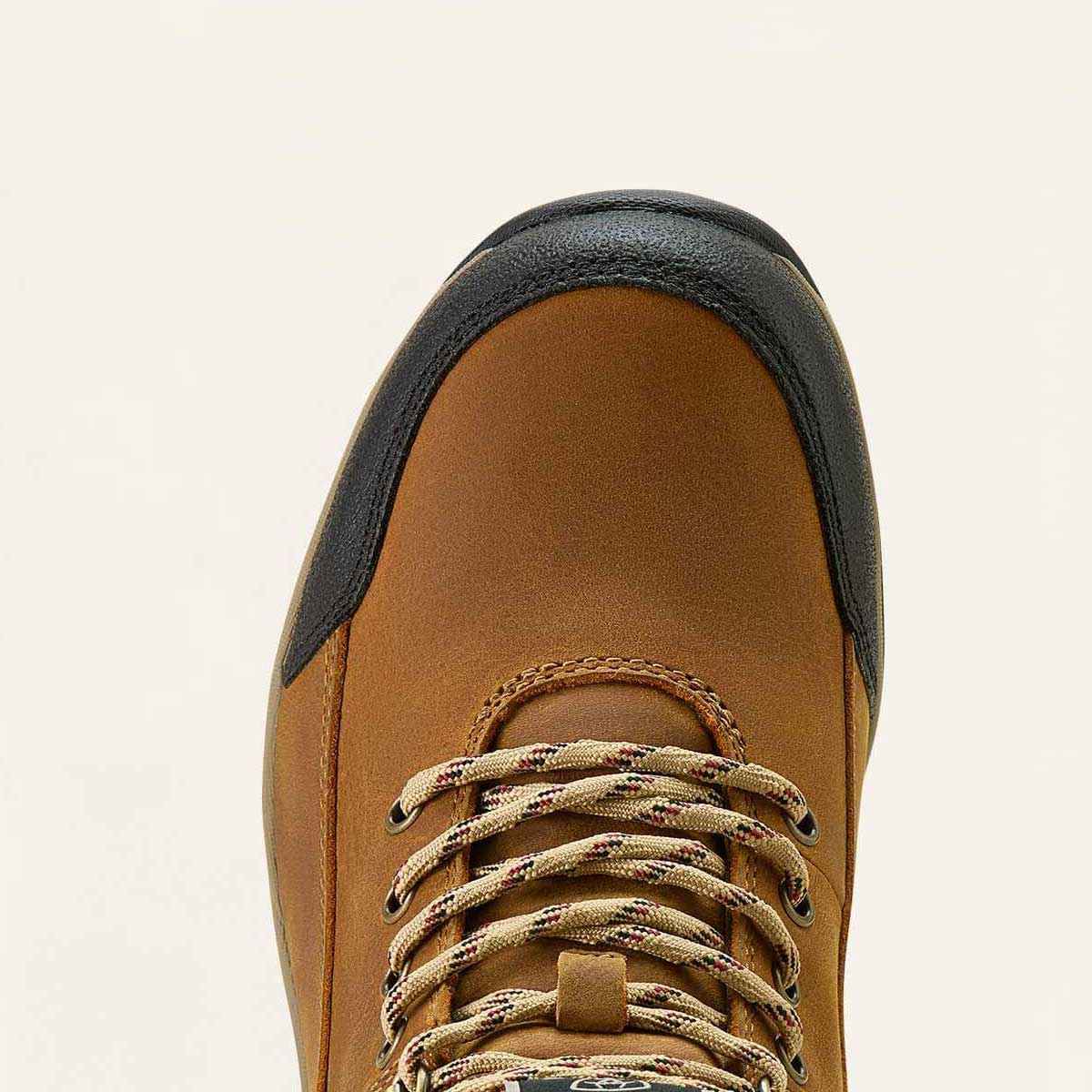 Brown boot with black top on a beige background