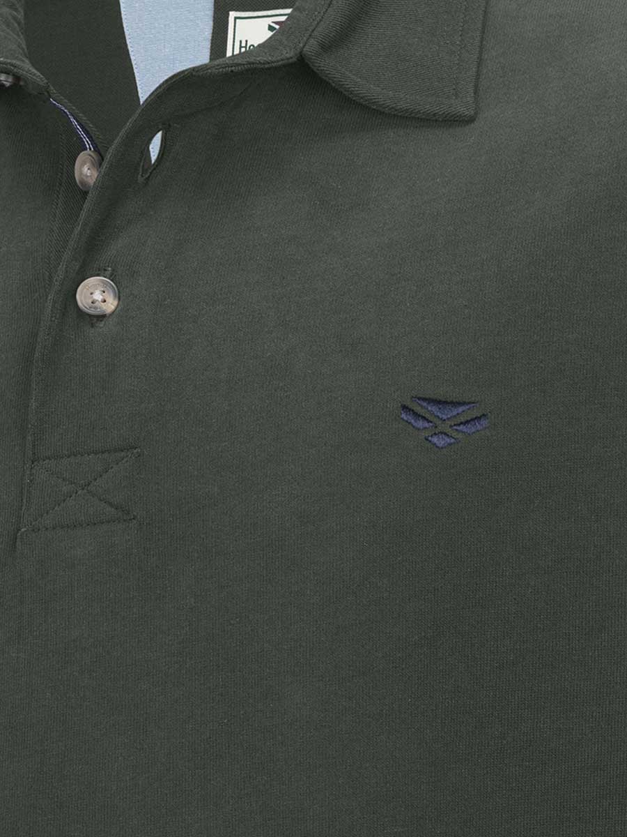 Close-up of a dark green polo shirt with a brand logo on the chest.