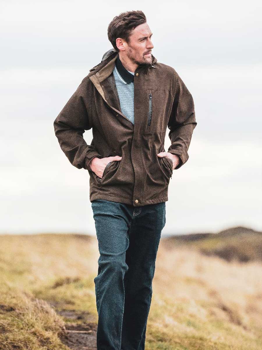 Man wearing a brown jacket in a natural landscape