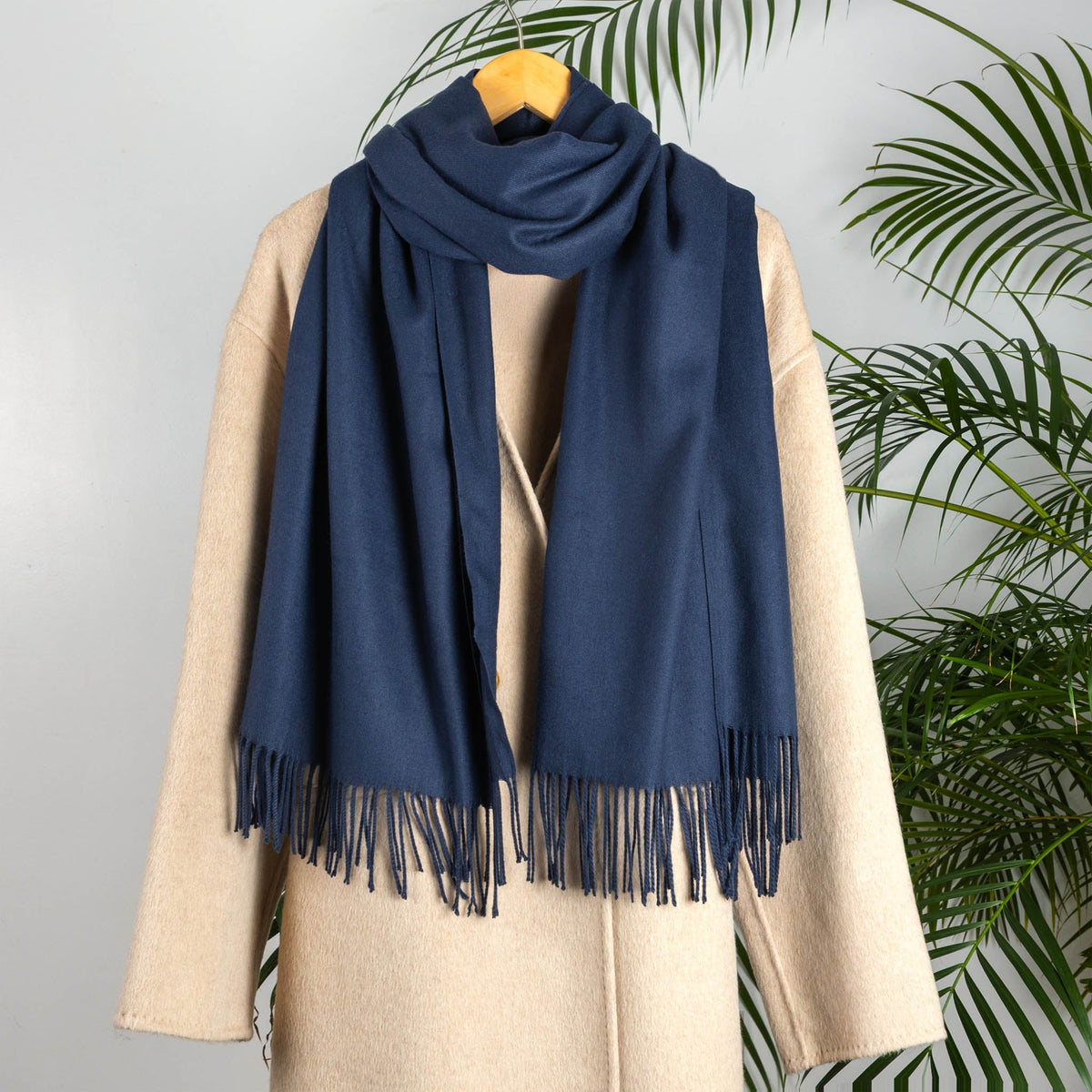 Women's plain pashmina in navy on a camel coat