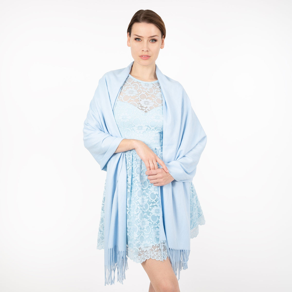 Woman wearing plain pashmina shawl in pale blue- draped over her shoulders