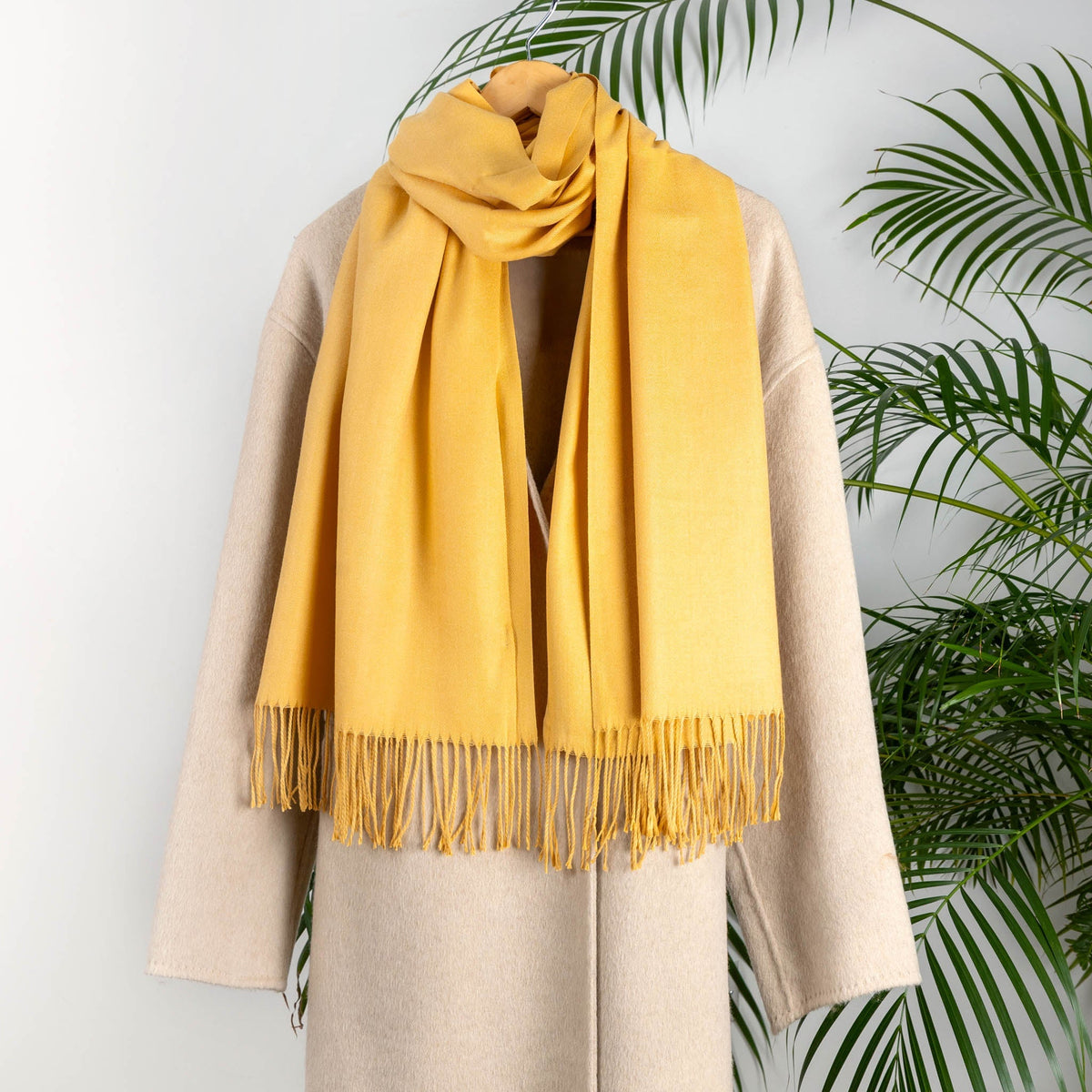 Women's plain pashmina in yellow on a camel coat