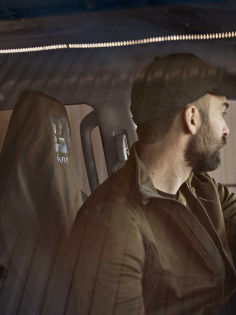 Härkila seat cover fitted inside a vehicle with a man seated in front