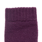 Women's cable knit gloves in purple, left hand close up. 
