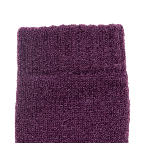Women's cable knit gloves in purple, left hand close up. 