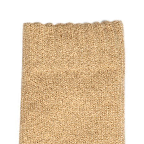Women's cable knit gloves in beige, left hand close up.