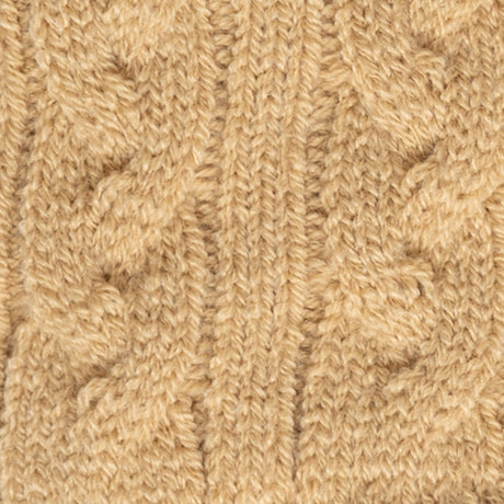 Women's cable knit gloves in beige, fabric close up. 