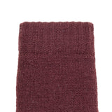 Women's cable knit gloves in burgundy, left hand close up. 