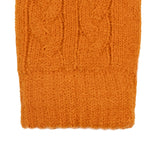 Women's cable knit gloves in orange, right hand close up. 