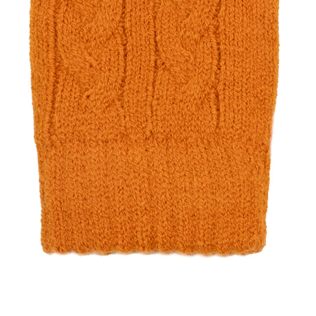 Women's cable knit gloves in orange, right hand close up. 
