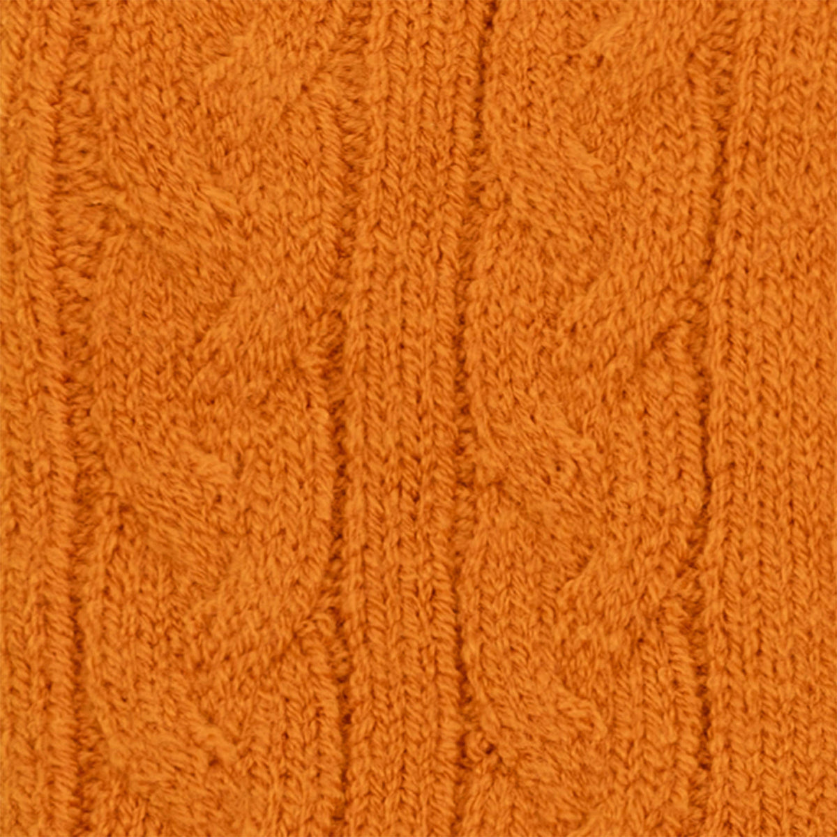 Women's cable knit gloves in orange, fabric close up. 