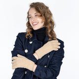 Woman crossing arms wearing cable knit gloves in beige, with white background in the studio.