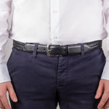 Man wearing woven leather belt with satin nickel buckle in black