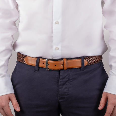 Man wearing woven leather belt with satin nickel buckle in tan, close up