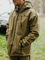 Swazi Ibex Waterproof Hunting Jacket in European Olive, worn outdoors showing the chest pockets and front zip