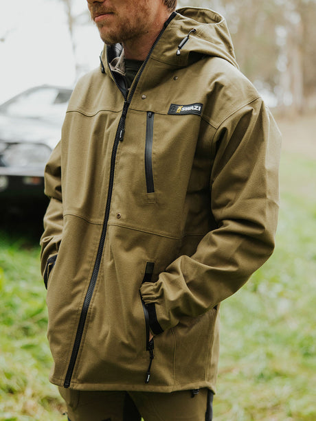 Swazi Ibex Waterproof Hunting Jacket in European Olive, worn outdoors showing the chest pockets and front zip