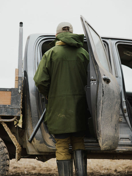 Swazi Wapiti XP Hunting Jacket in Olive, rear view while getting into a vehicle