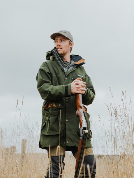 Swazi Wapiti XP Hunting Jacket in Olive, worn standing in a field