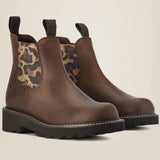 Brown Chelsea boots with leopard print patch on a beige background