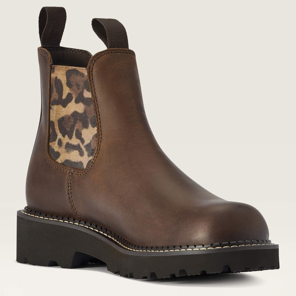 Brown leather boot with leopard print patch on a beige background