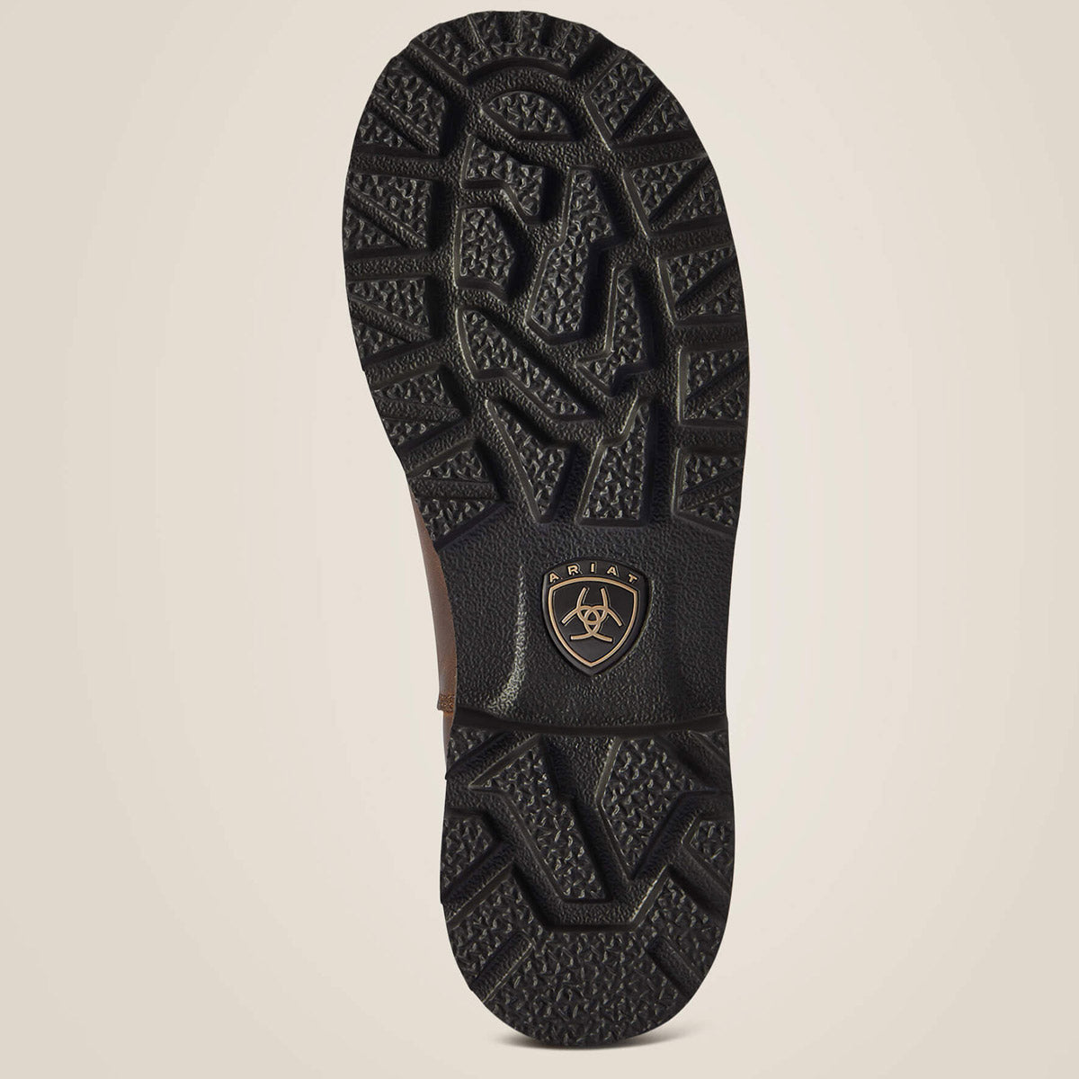 Close-up of a black boot sole with a brand logo on a beige background