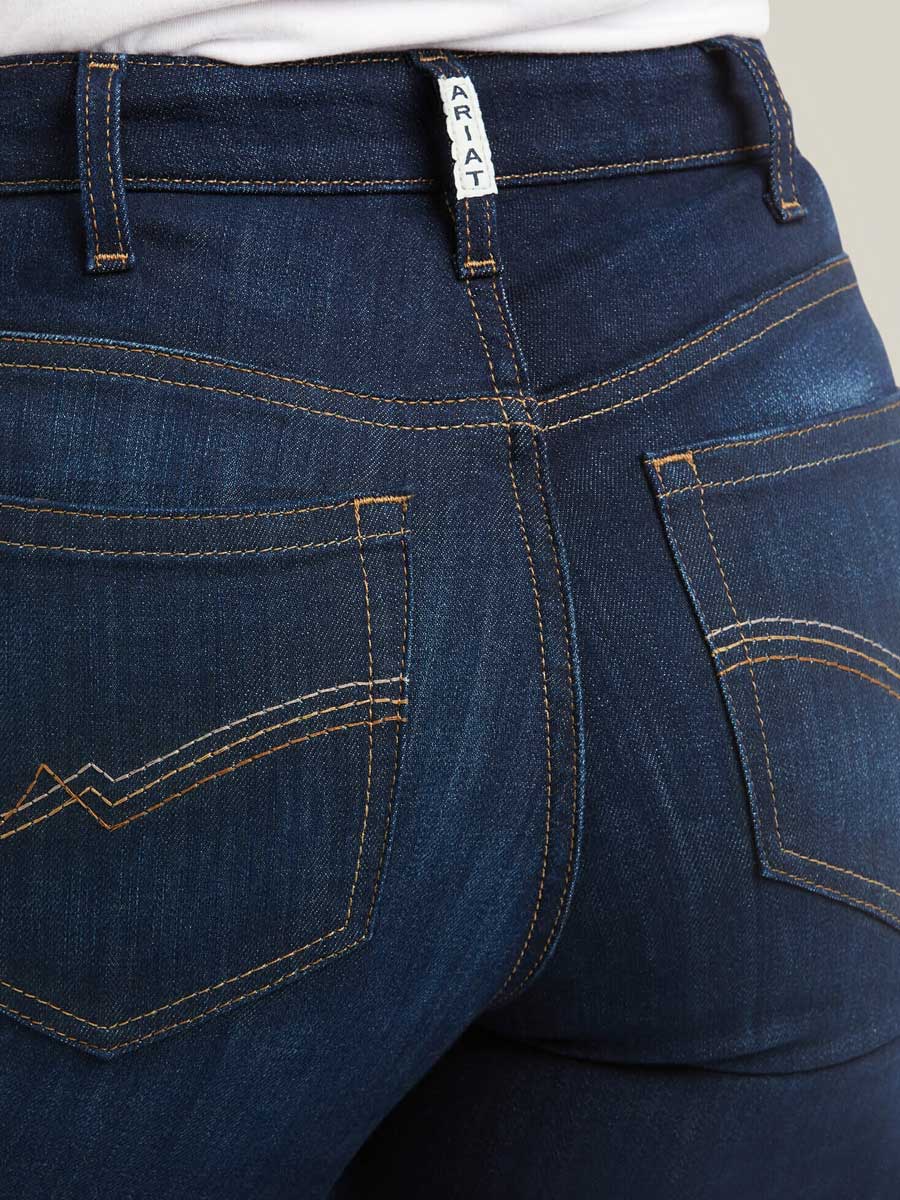 Close-up of blue jeans with a brand label on the waistband.