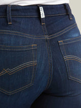 Close-up of blue jeans with a brand label on the waistband.