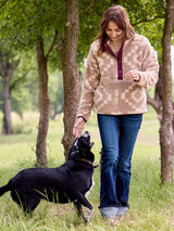Woman walking a black dog in a park