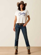 Woman wearing a white t-shirt with text, blue jeans, and a brown cowboy hat on a plain background