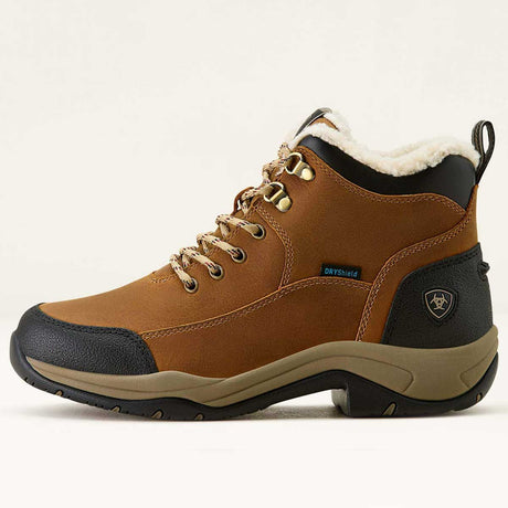 Brown winter boot with black sole on a light beige background