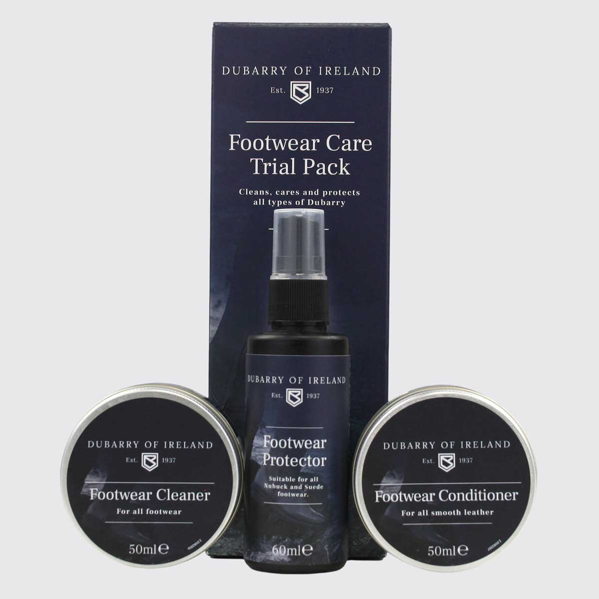 Dubarry of Ireland Footwear Care Trial Pack including a Footwear Protector spray bottle, Footwear Cleaner tin, and Footwear Conditioner tin, displayed in front of its dark navy blue retail box on a light gray background.