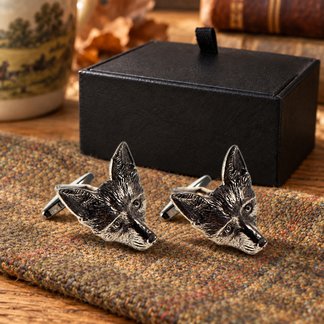 Farley's fox head English pewter cufflinks displayed on tweed beside the black presentation box