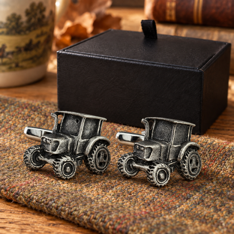 Dark pewter modern tractor cufflinks displayed on tweed beside Farley's black presentation box