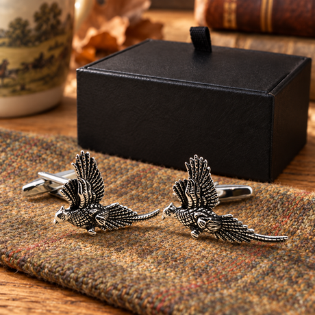 Farley's rhodium-plated pheasants in flight cufflinks displayed on tweed beside the black presentation box