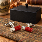 Red and silver-tone shotgun cartridge cufflinks on country tweed beside Farley's black presentation box