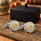 Pair of Farley's two tone rhodium plated shotgun cartridge cap cufflinks on tweed beside the black presentation box
