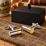 Pair of Farley's two tone shotgun cartridge cufflinks on tweed beside the black presentation box