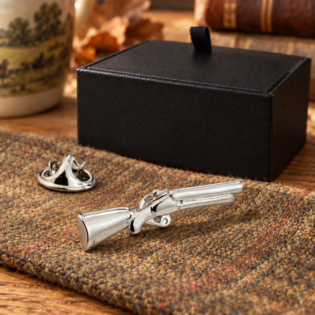Farley's silver rhodium plated shotgun lapel pin badge on tweed beside the black presentation box