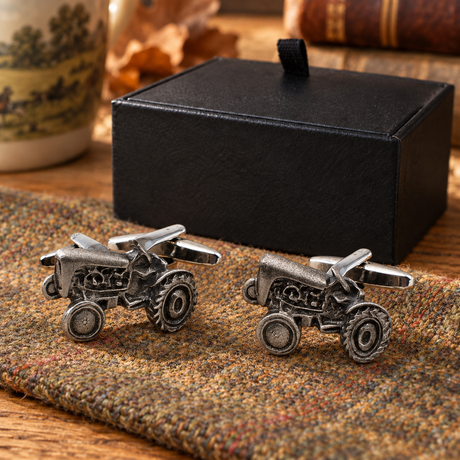 Vintage tractor cufflinks displayed on country tweed beside Farley's black presentation box