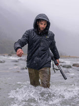 Swazi Geyser Jacket in Black, worn while wading through a river