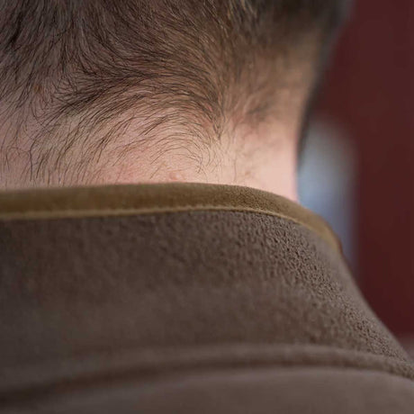 Close-up of the back of a person's neck and hair, wearing a brown textured fleece collar.