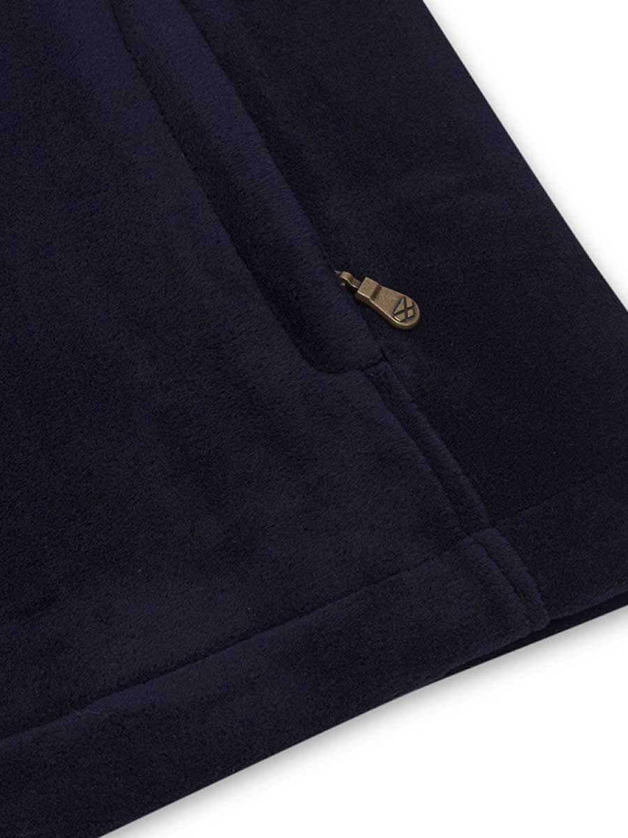 Close-up of a navy blue garment with a gold button on a white background