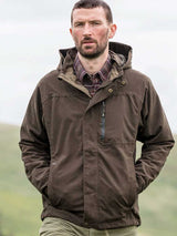 Man wearing a brown jacket outdoors with a blurred natural background