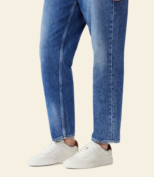RM Williams Men's Sandbar Leather Trainers - White, rear view worn with jeans