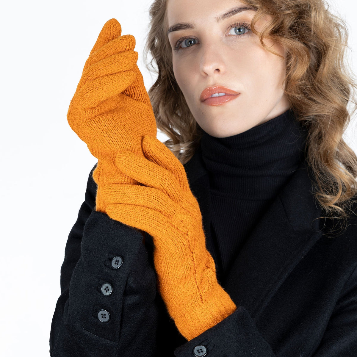 Woman wearing cable knit gloves in pumpkin