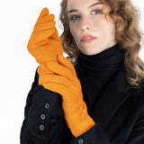 Woman wearing cable knit gloves in pumpkin