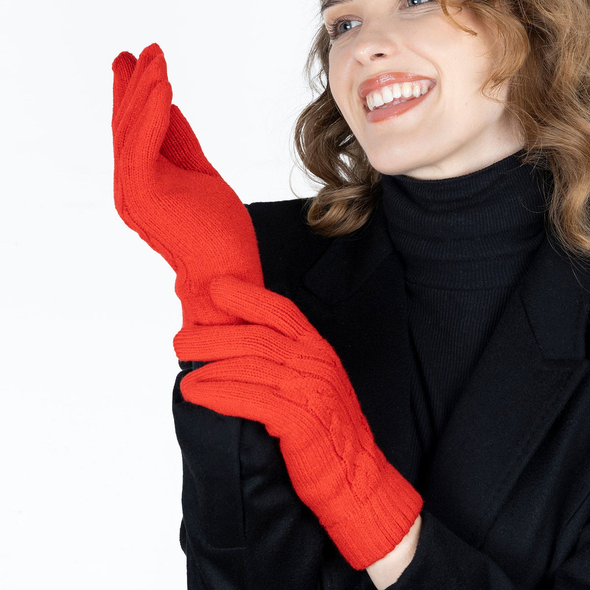 Woman wearing cable knit gloves in berry